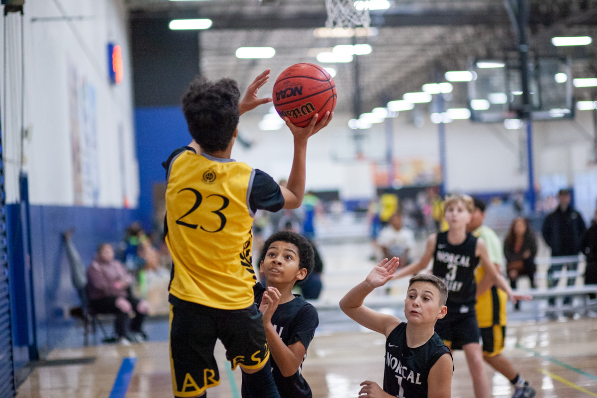 Ares basketball player going for a layup vs defenders